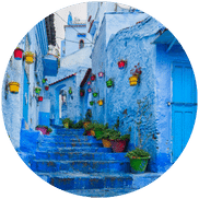 A sunny spring day in Chefchaouen showing the vibrant blue streets and blooming flowers, highlighting the best time to visit.