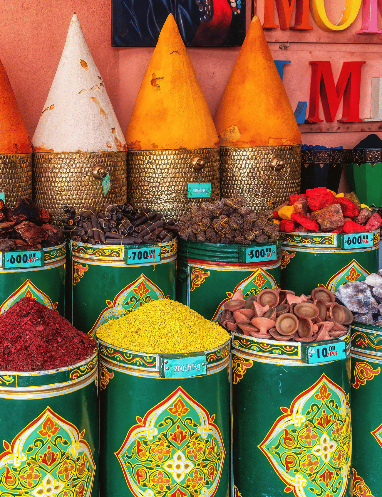 Vibrant spice stalls with colorful cones of spices in a Moroccan market, representing the local flavor offered by a Morocco local travel agency.